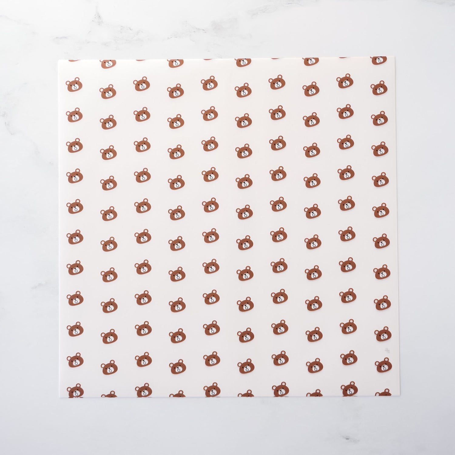 White paper with brown bear pattern on a white background