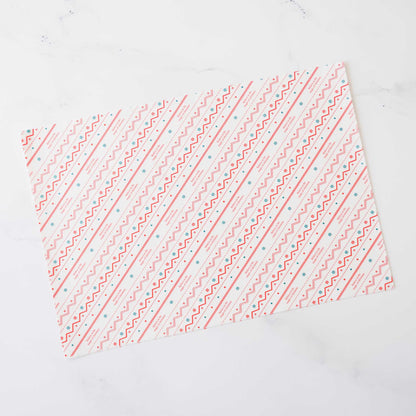 Pink and teal geometric patterned wrapping paper. The design features diagonal lines of repeating zigzags and dots on a white background. This decorative paper is ideal for gift wrapping and crafting projects.