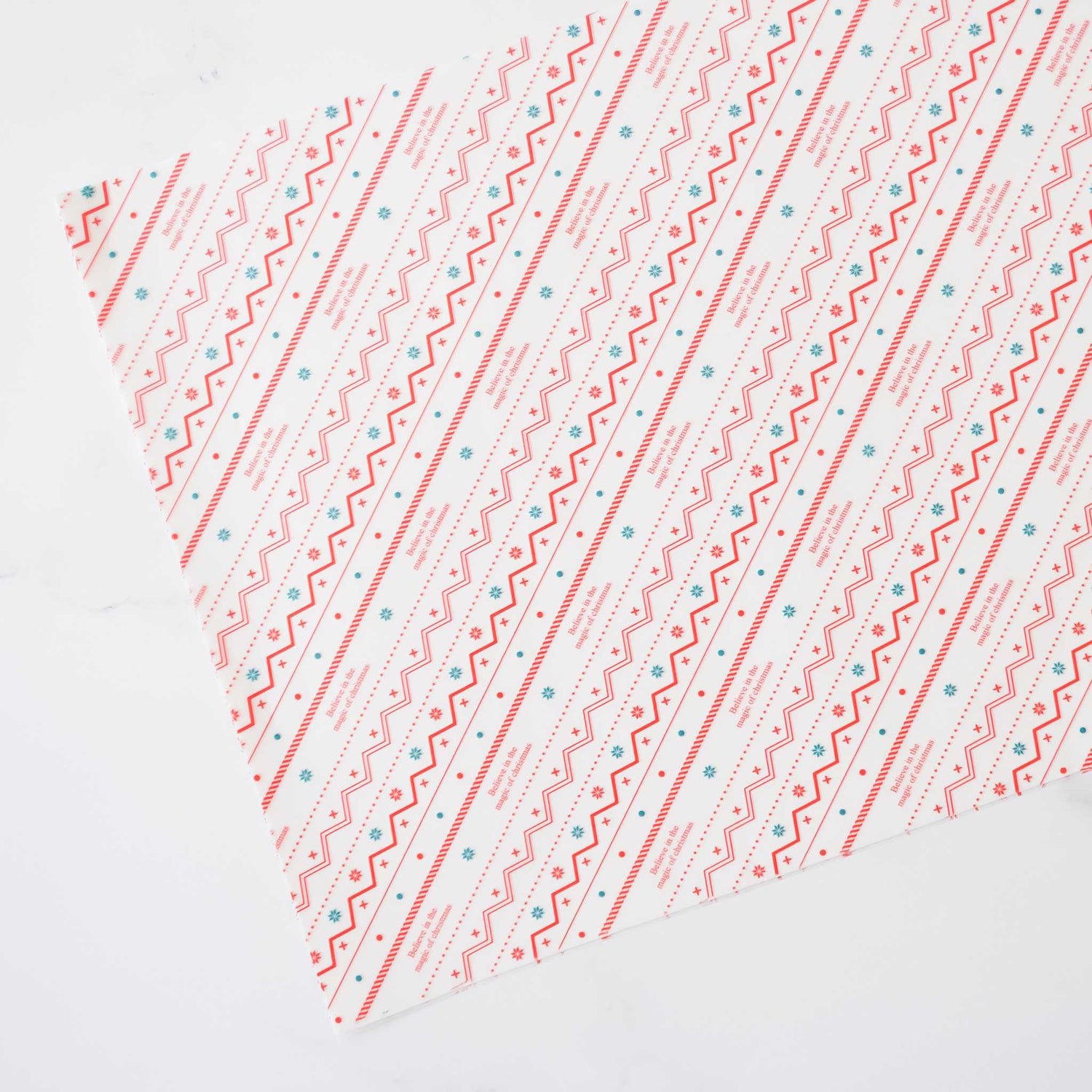  Sheets of deli paper with a festive red, green, and white Nordic print design, pre-cut for food service use.