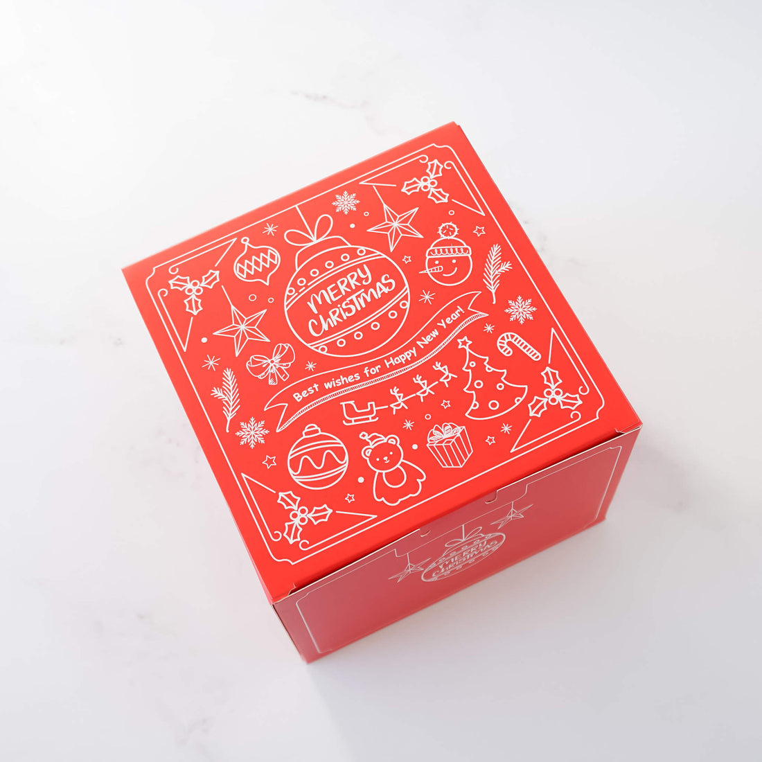 A red Christmas cookie box with white Christmas ornaments printed on the lid.