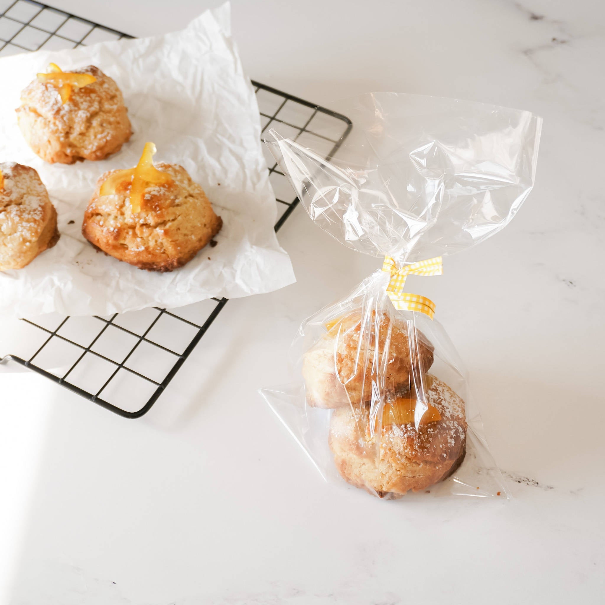 Clear flat cellophane bags with a twist-tie closure, displayed alongside pastries on a cooling rack.