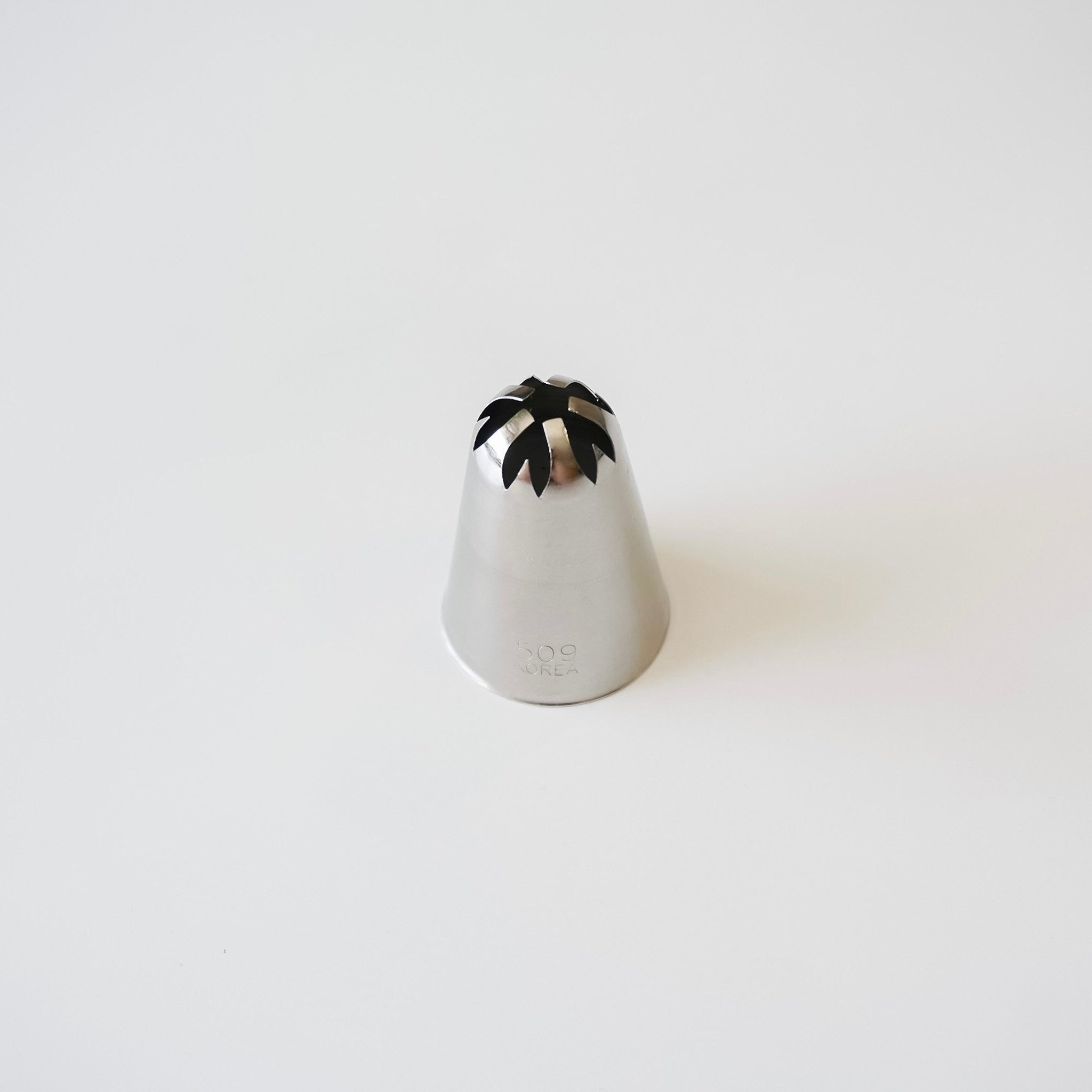 Stainless steel piping tip with closed star top on a white background