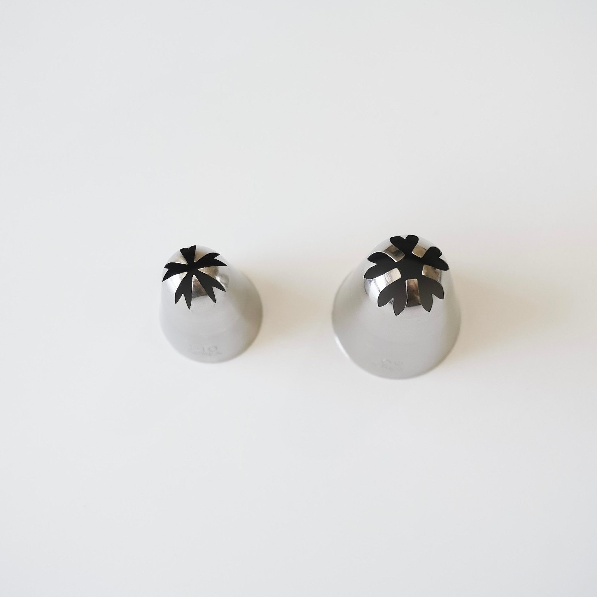 Two stainless steel piping tips with closed star design on a white background