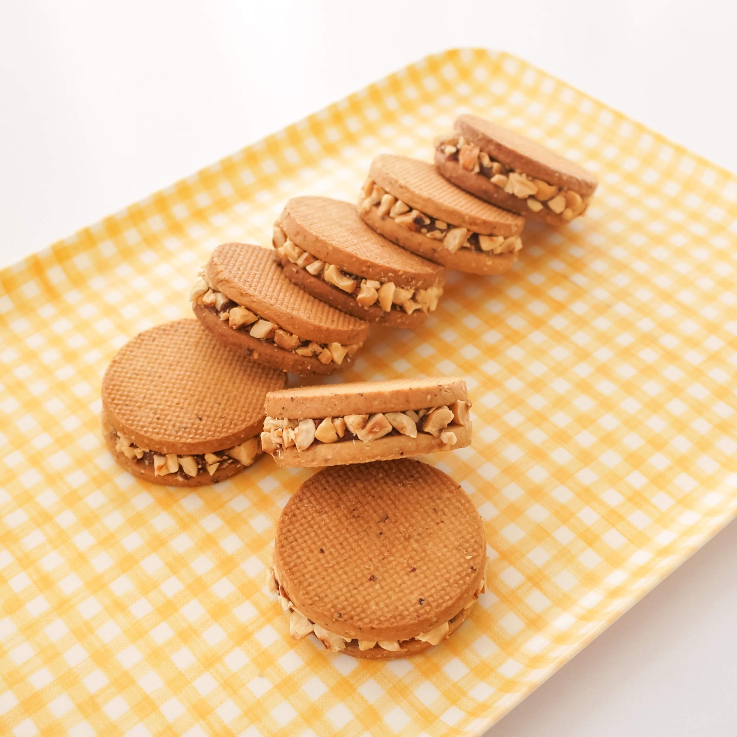 Cookies with walnut filling on a yellow checkered plate
