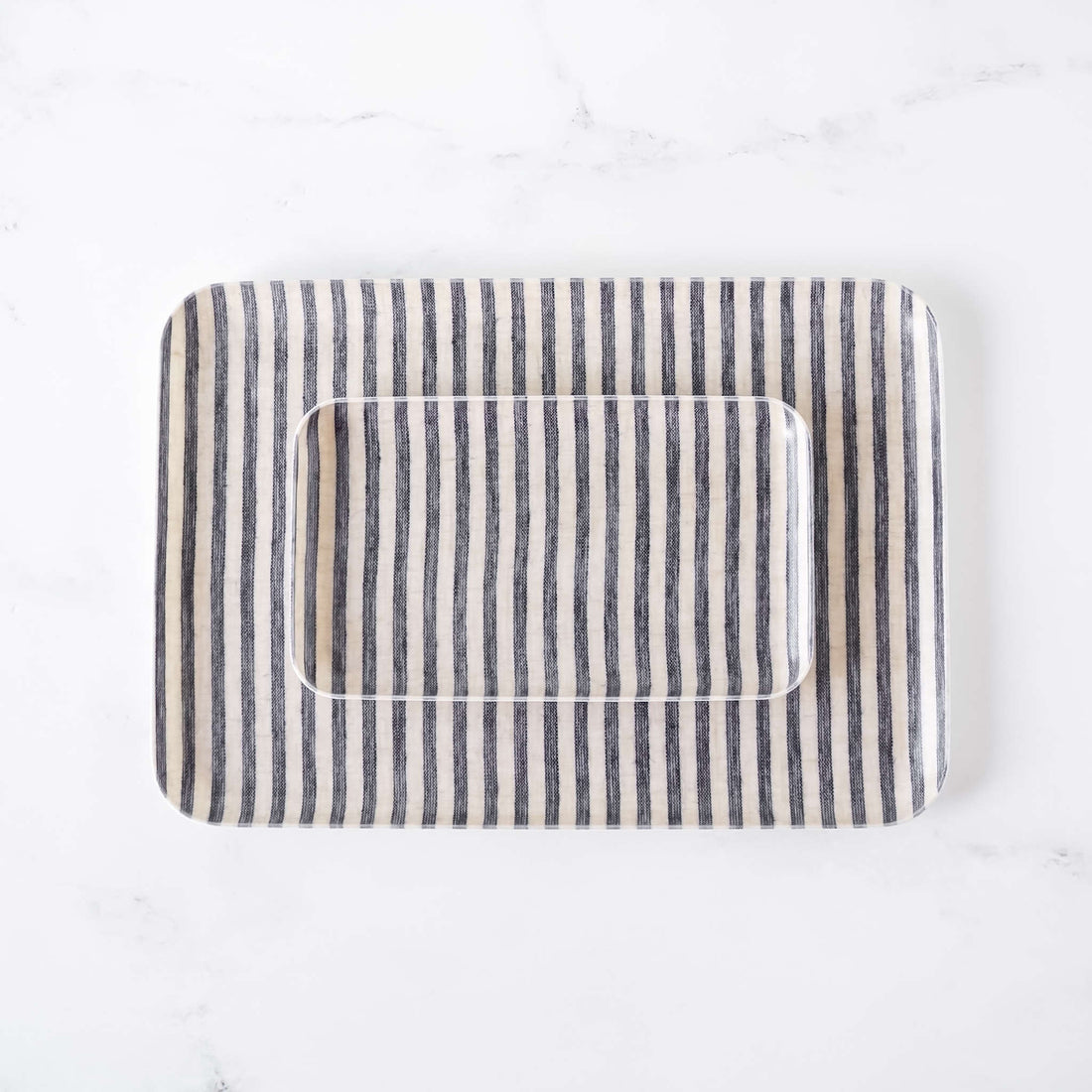 Rectangular serving tray with striped linen fabric cover on a white background