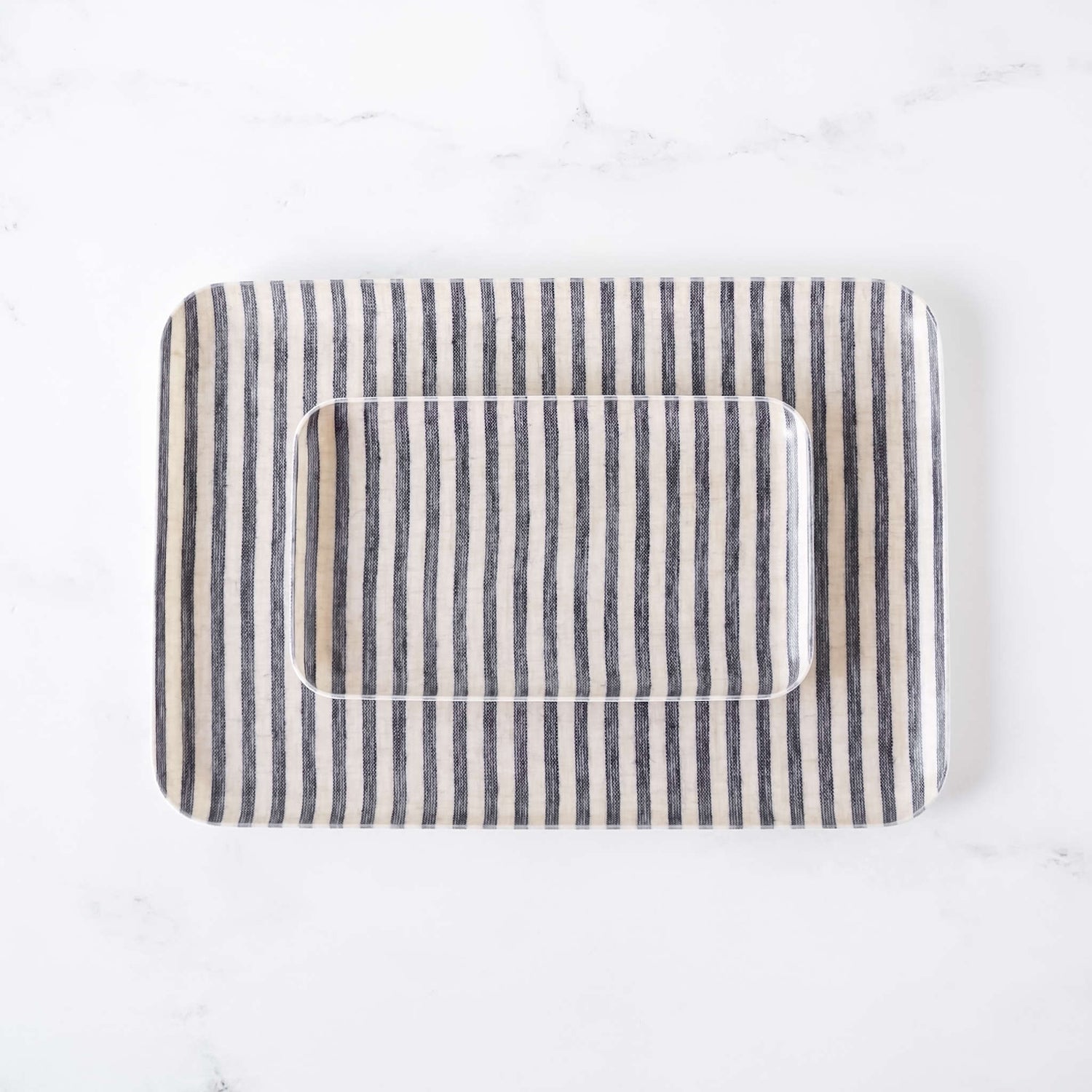 Rectangular serving tray with striped linen fabric cover on a white background