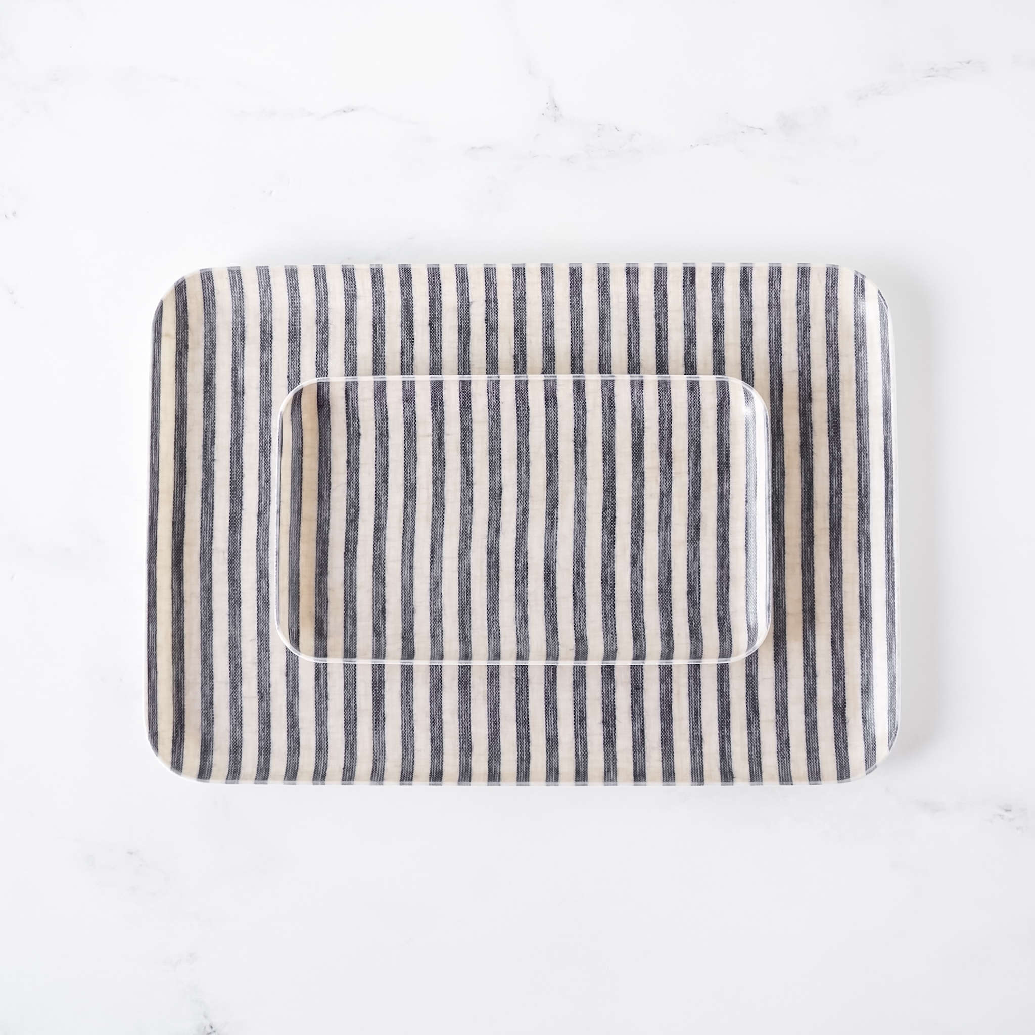 Rectangular serving tray with striped linen fabric cover on a white background