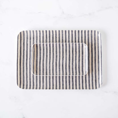 Rectangular serving tray with striped linen fabric cover on a white background