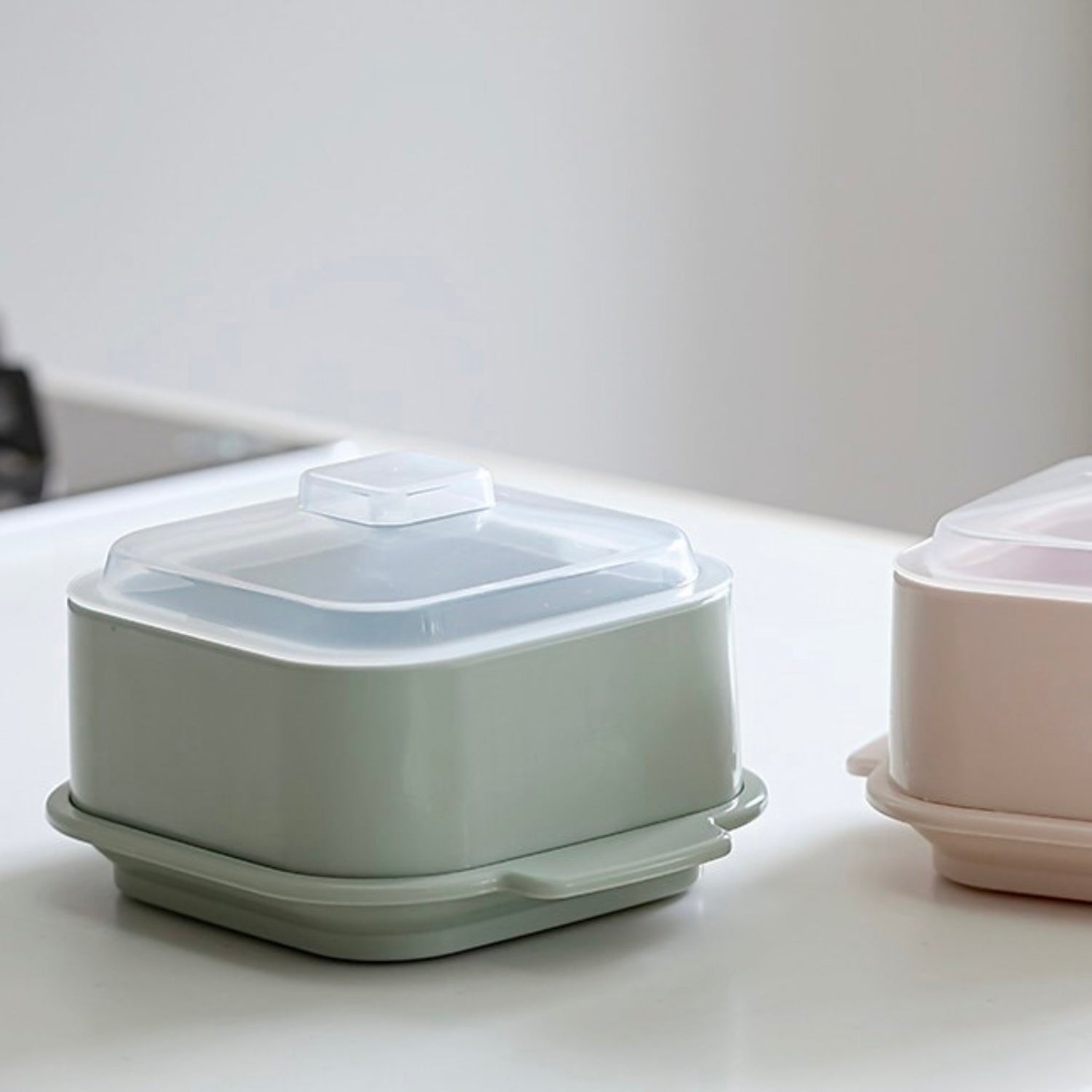 Two plastic containers with lids on a light surface