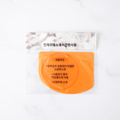 Orange scraper with Korean text on a white background