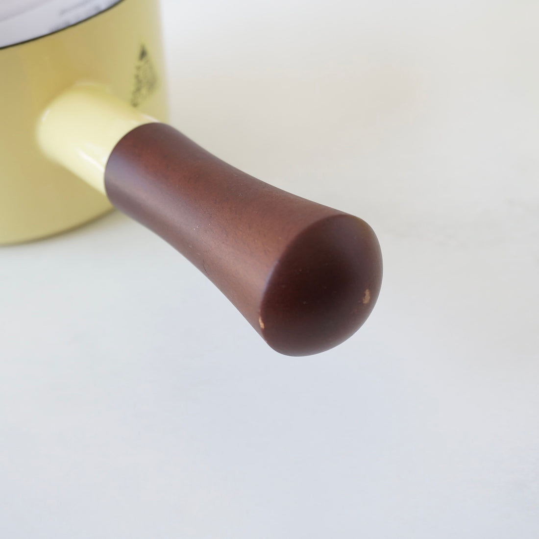 Close-up of a brown handle on a pot with a white background