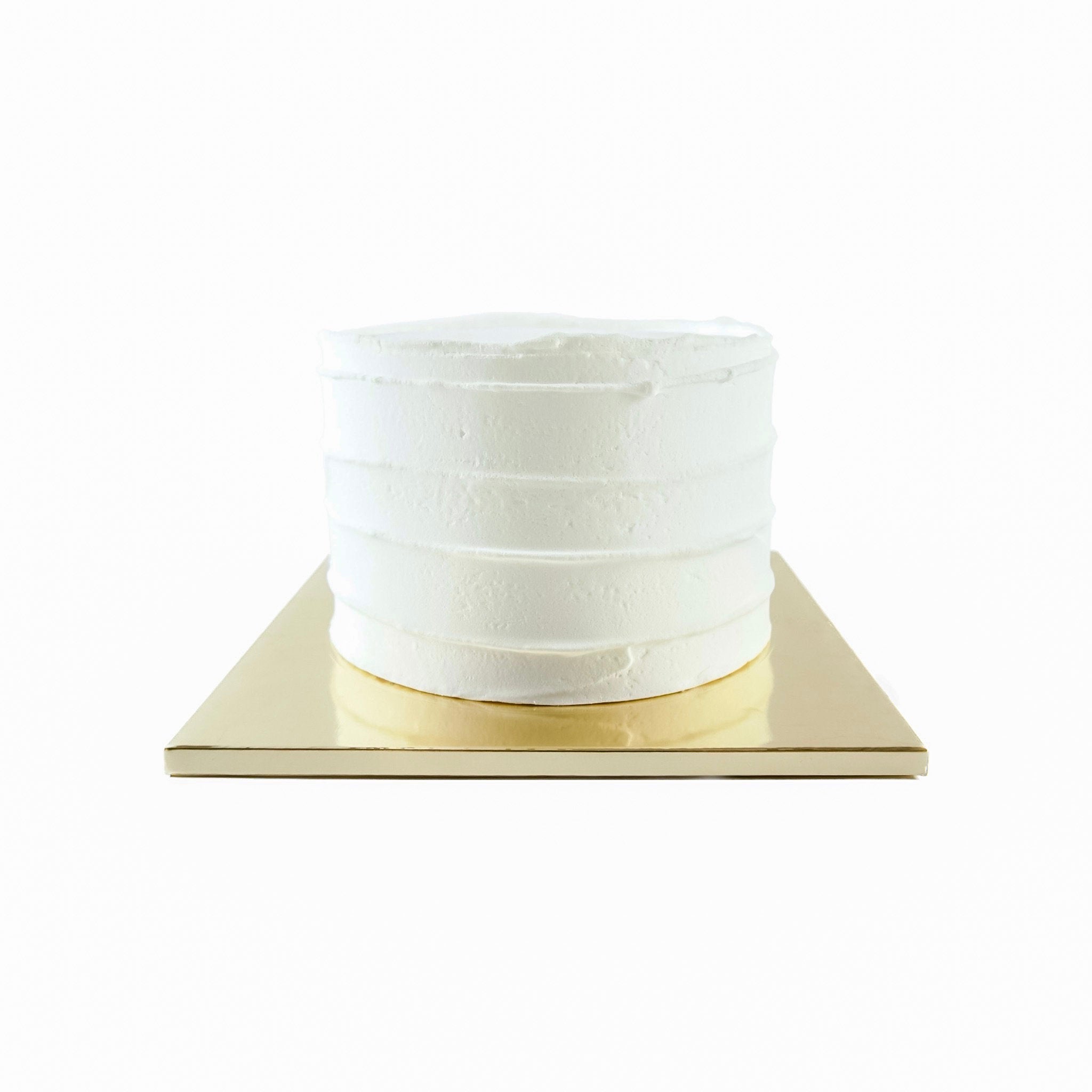 A white cake with a smooth, white frosting on a gold cake board.