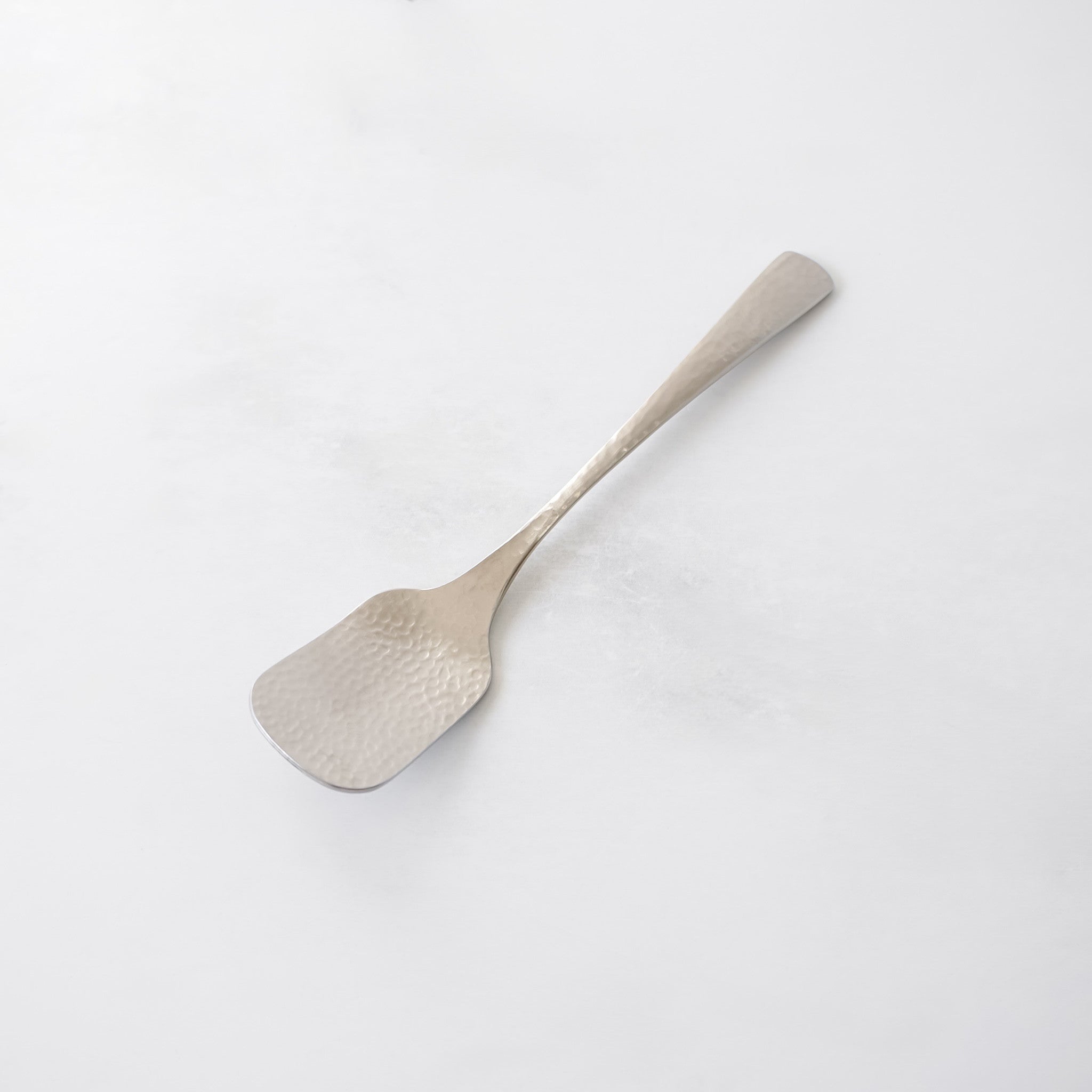 A silver-colored serving utensil with a rectangular head and a long, slender handle. The head has a textured, hammered appearance. The utensil is designed for serving ice cream and is made of stainless steel.