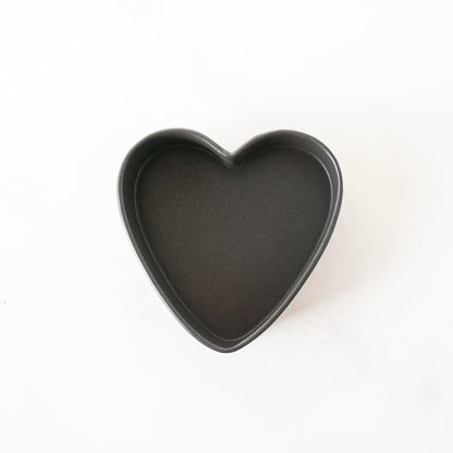 Heart-shaped black baking pan on a white background