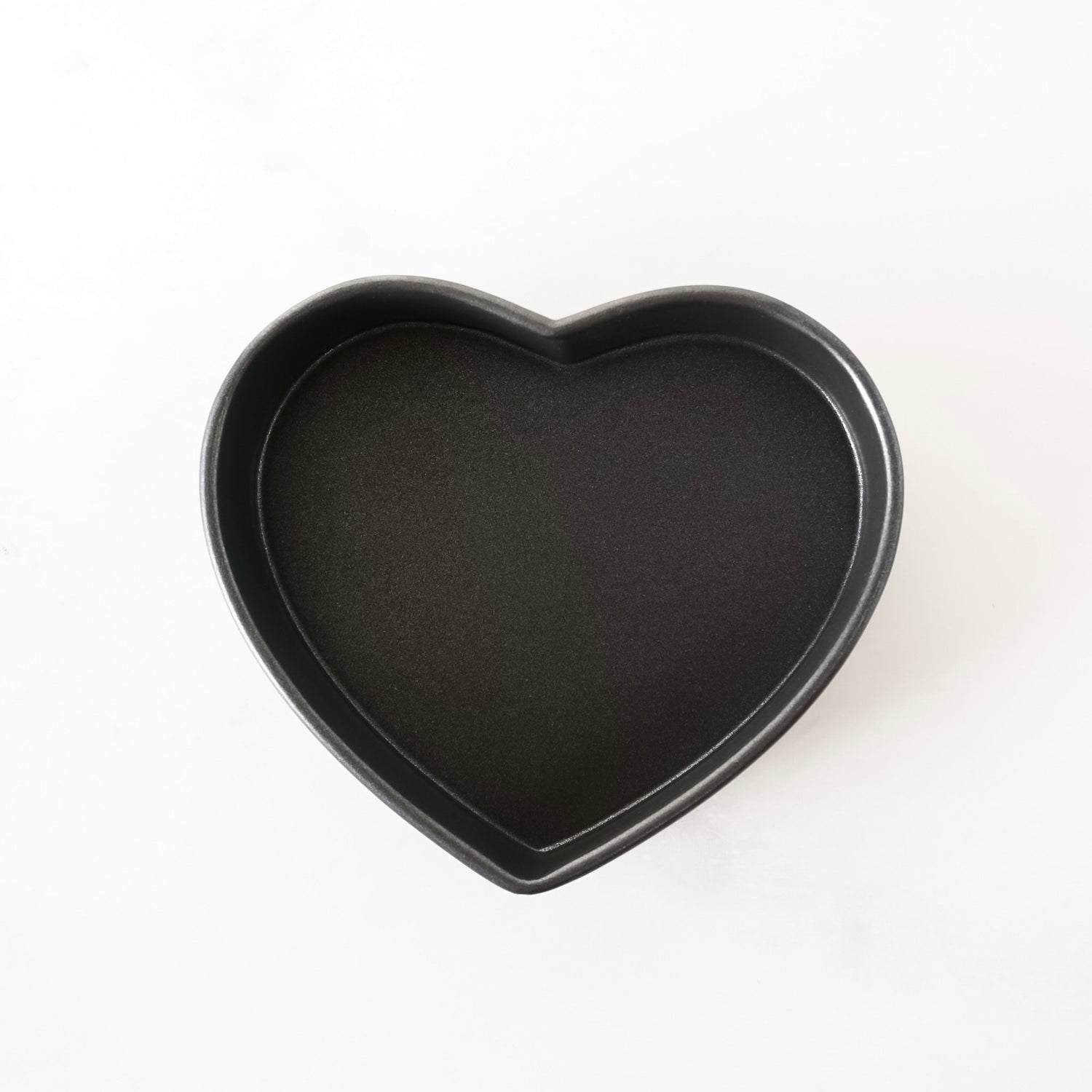 Heart-shaped black baking pan on a white background