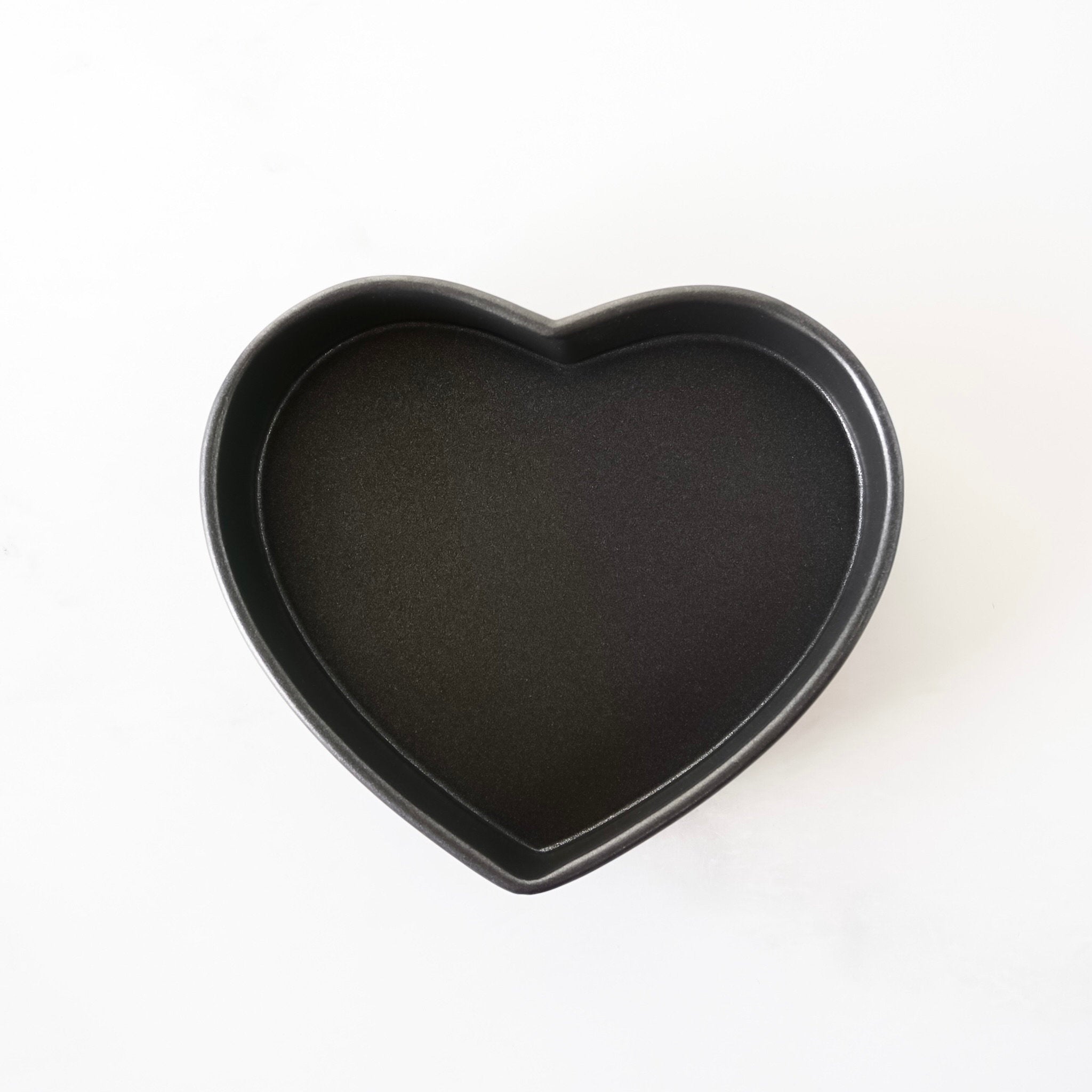 Heart-shaped black baking pan on a white background