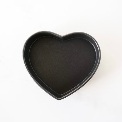 Heart-shaped black baking pan on a white background