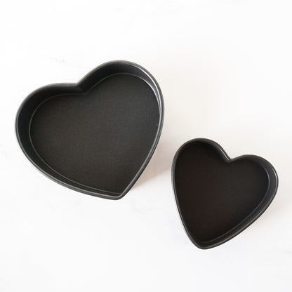 Two heart-shaped baking pans on a white background