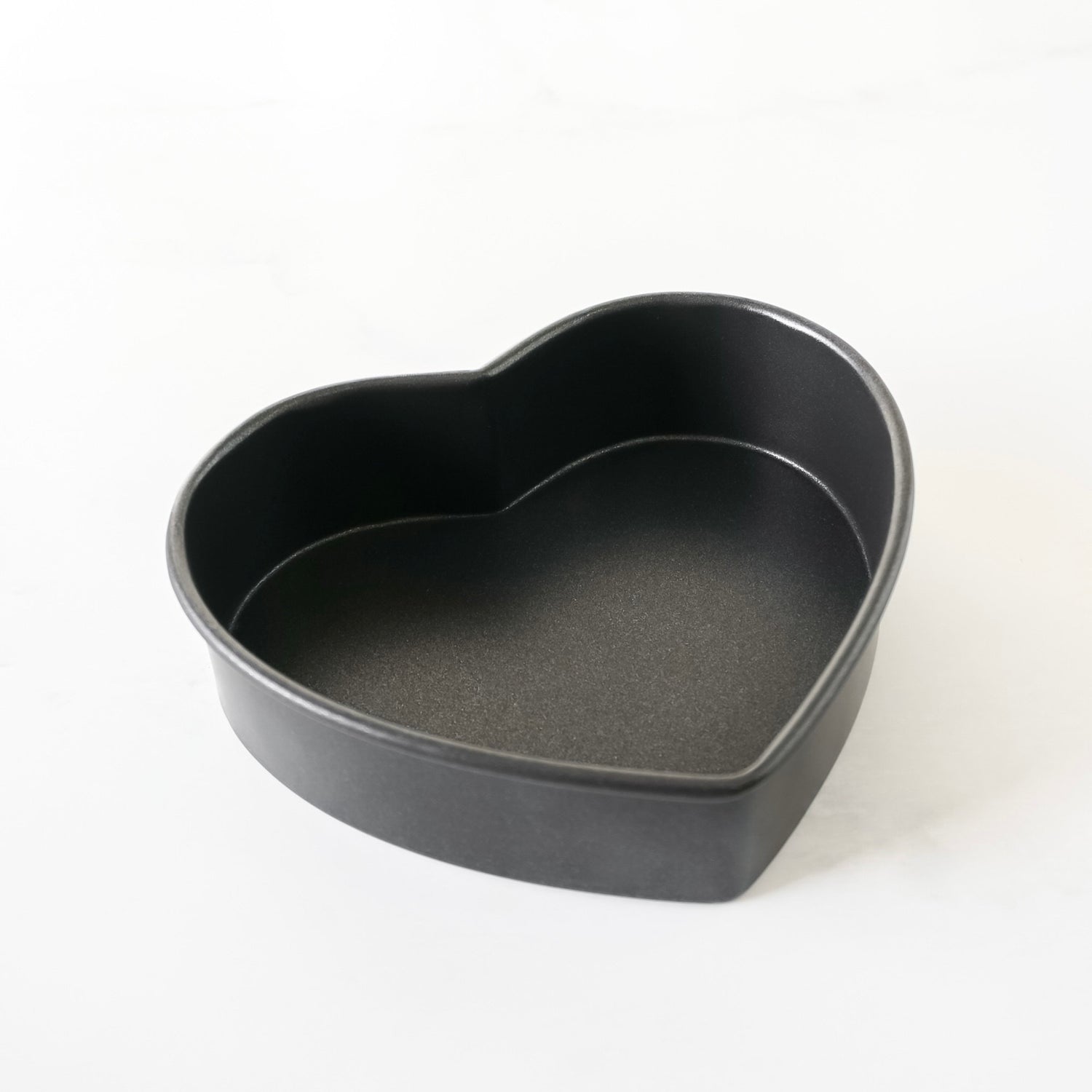 Heart-shaped black baking pan on a white background