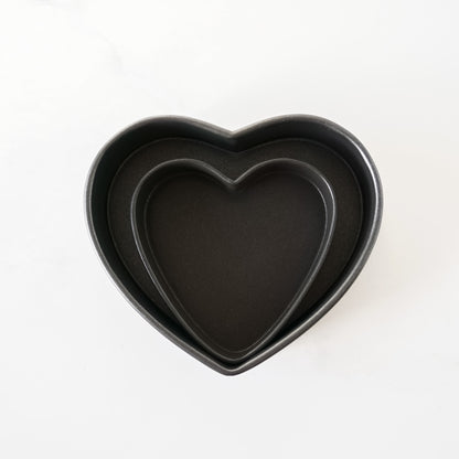 Two heart-shaped baking pans on a white background