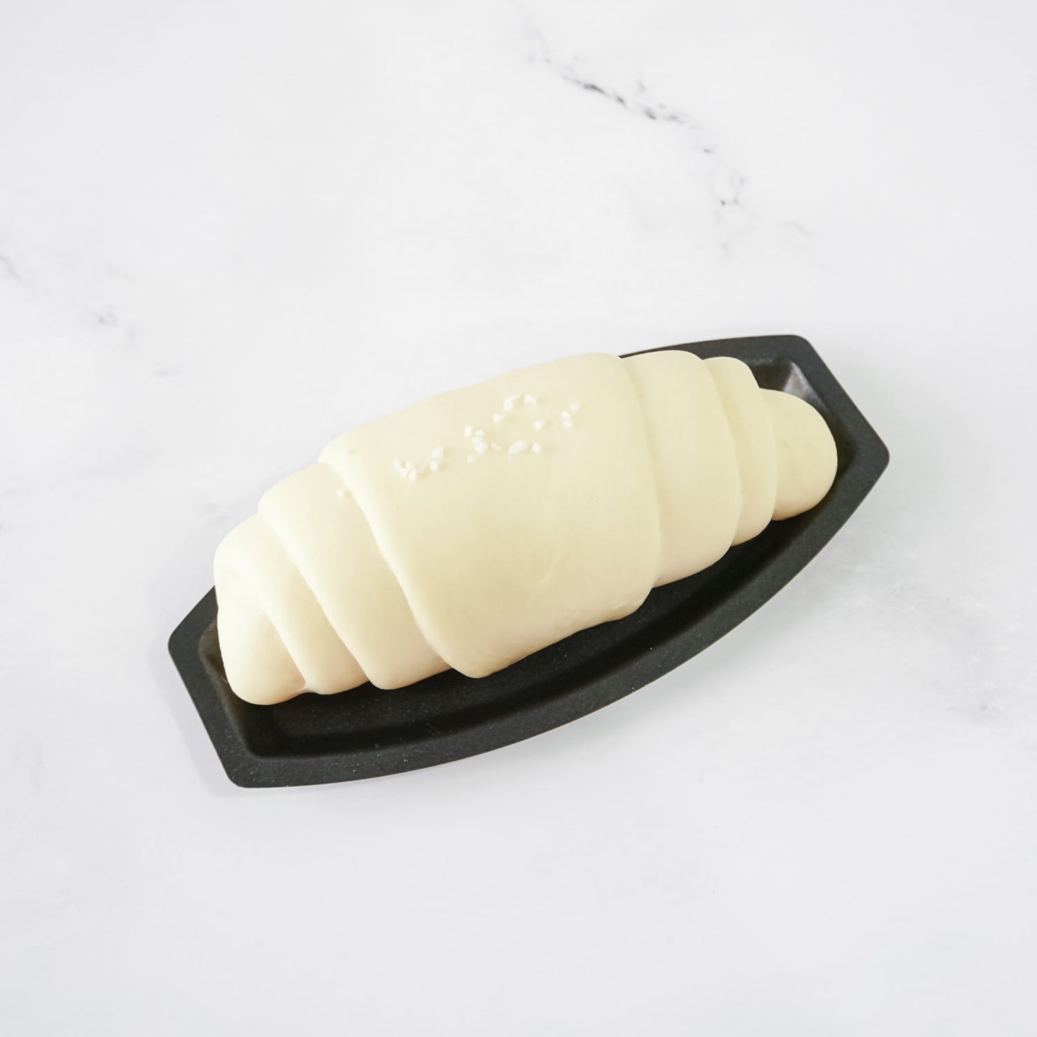Salt bread mold with a salted butter roll on a white background
