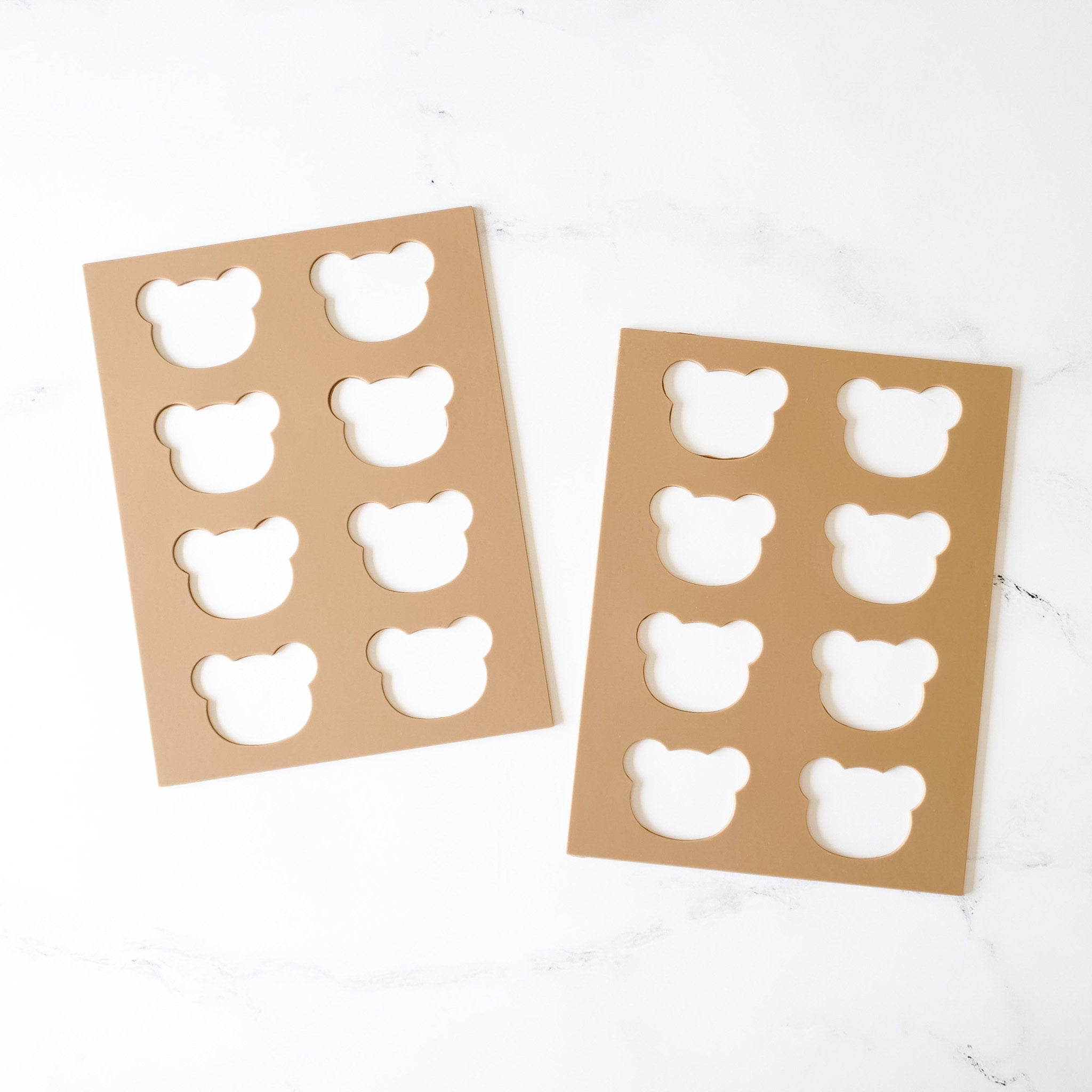 Two silicone cookie stencils with shapes for a bear, laid out on a white surface.