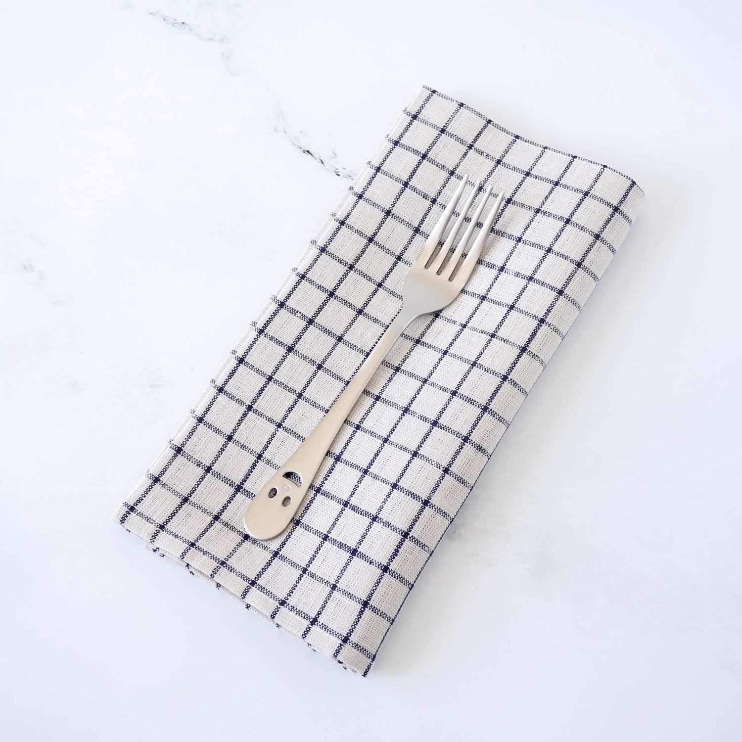 Checkered napkin with a fork on a white background