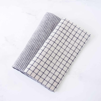 Two folded checkered linen napkins, one gray and white, one black and white, on a white background.