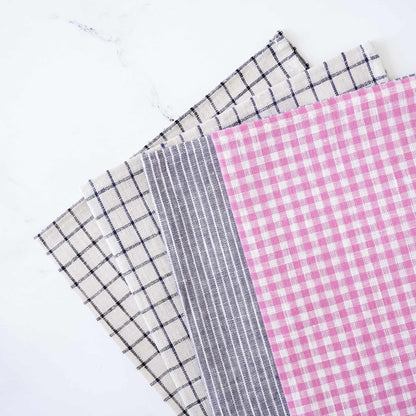 Four linen fabric placemats with different patterns on a white background