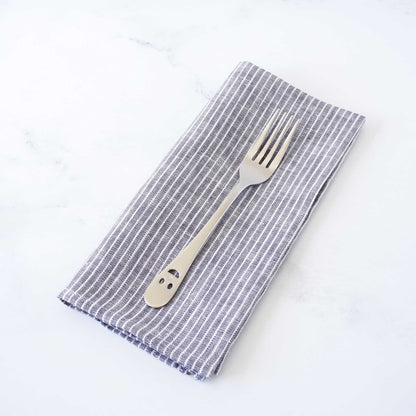 Folded striped napkin with a fork on a white background