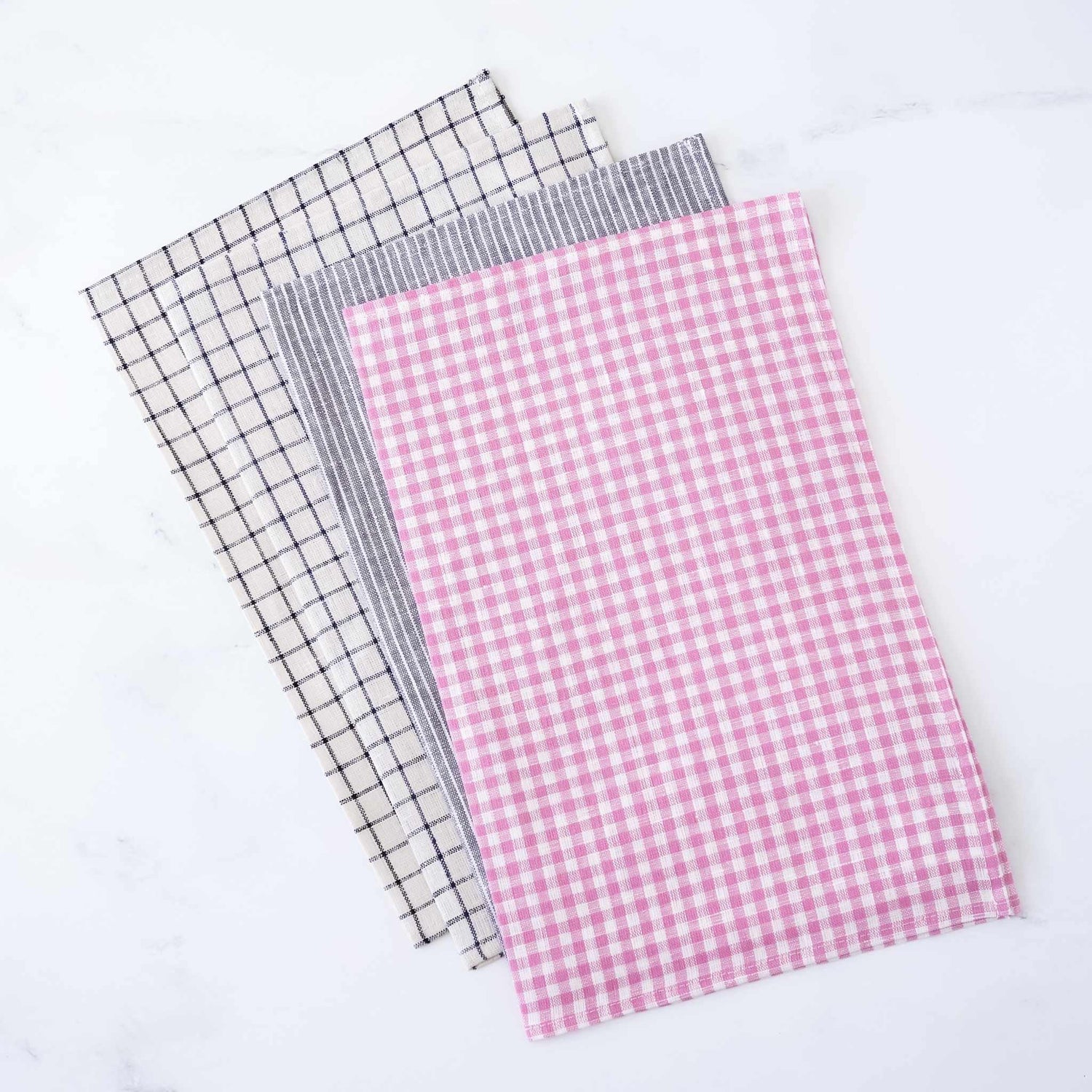 Four checkered fabric placemats in black and white, gray and white, and pink and white on a white background.