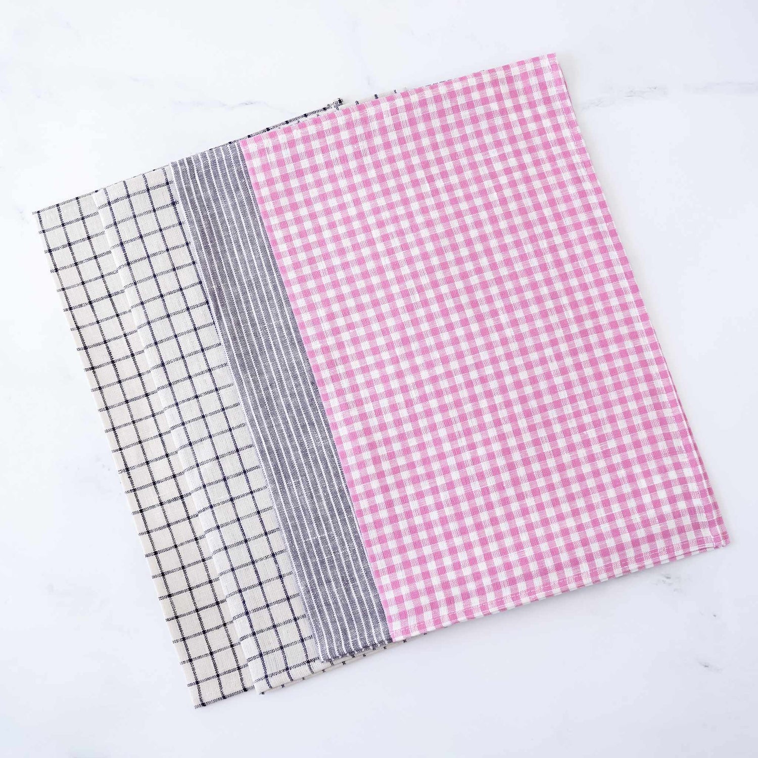 Four linen fabric placemats with different patterns on a white background