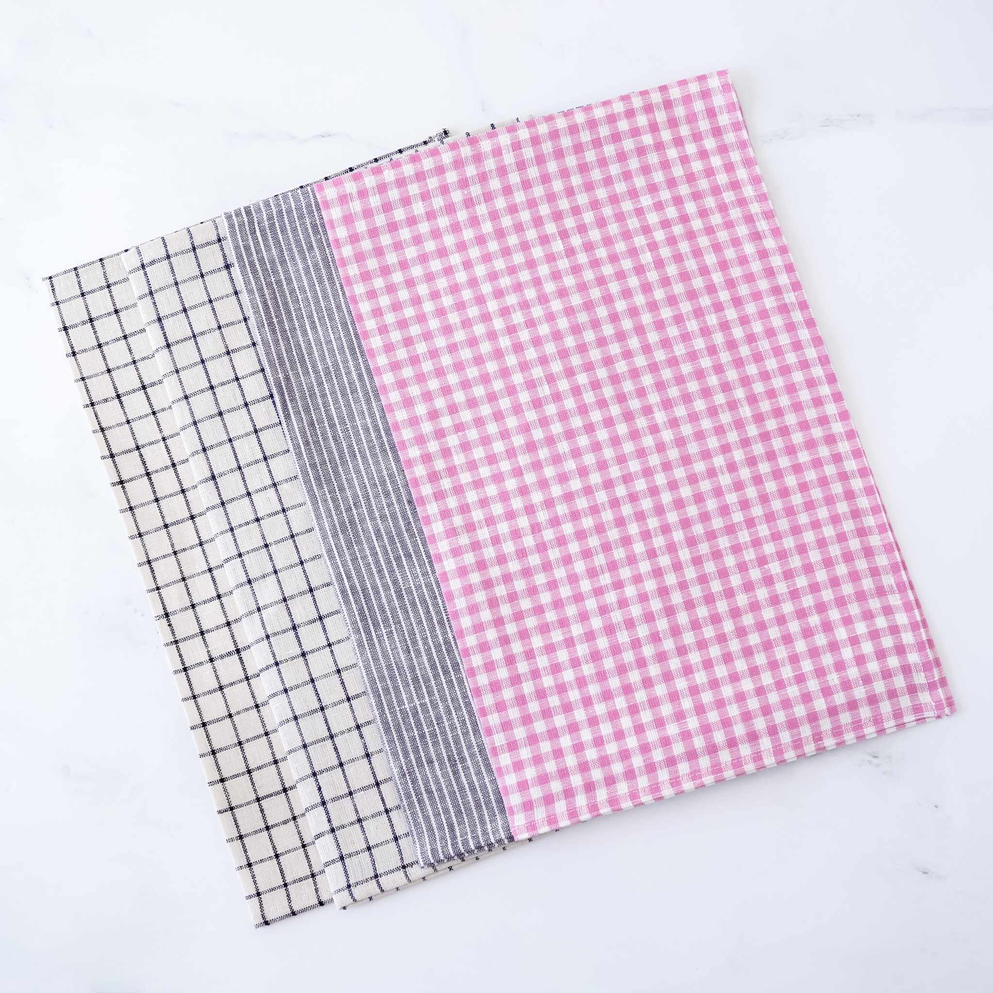 Four linen fabric placemats with different patterns on a white background