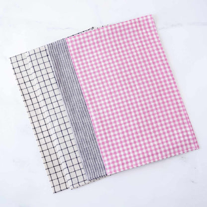 Four linen fabric placemats with different patterns on a white background