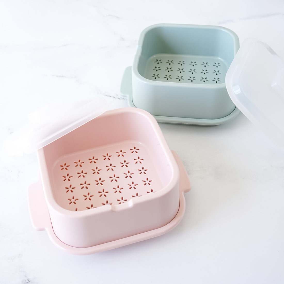 Two microwave steamers, one pink and one light blue, on a white background.