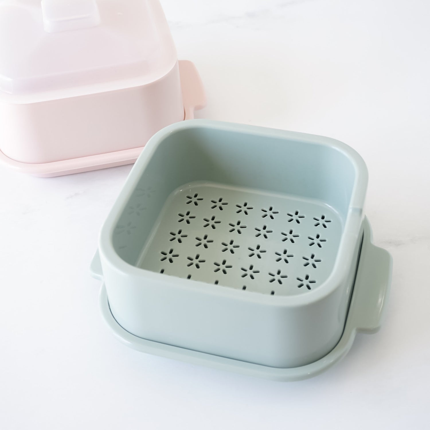 Light blue microwave steamer with floral pattern on a white background