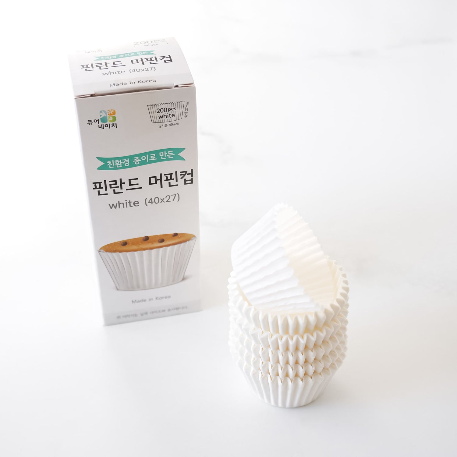 White muffin cups with a box on a white background