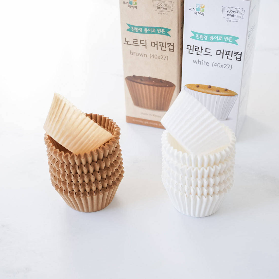 Brown and white cupcake liners with packaging on a white background