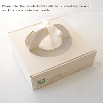 Beige gift box with a bow on a white background, featuring a QR code and sustainability marking.
