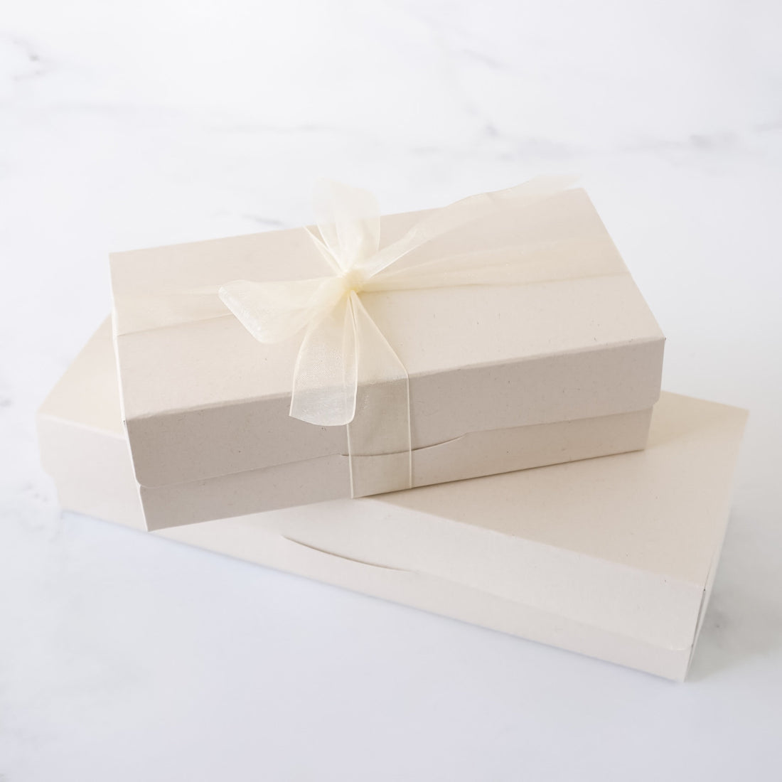 Beige gift box with a ribbon on a white background