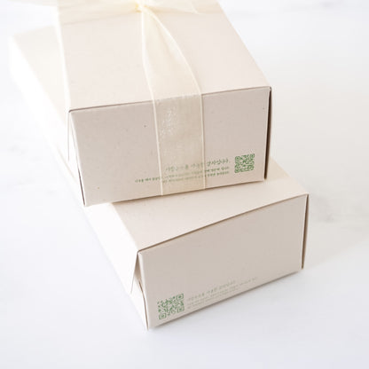 Two beige cardboard boxes with green QR codes on a white background
