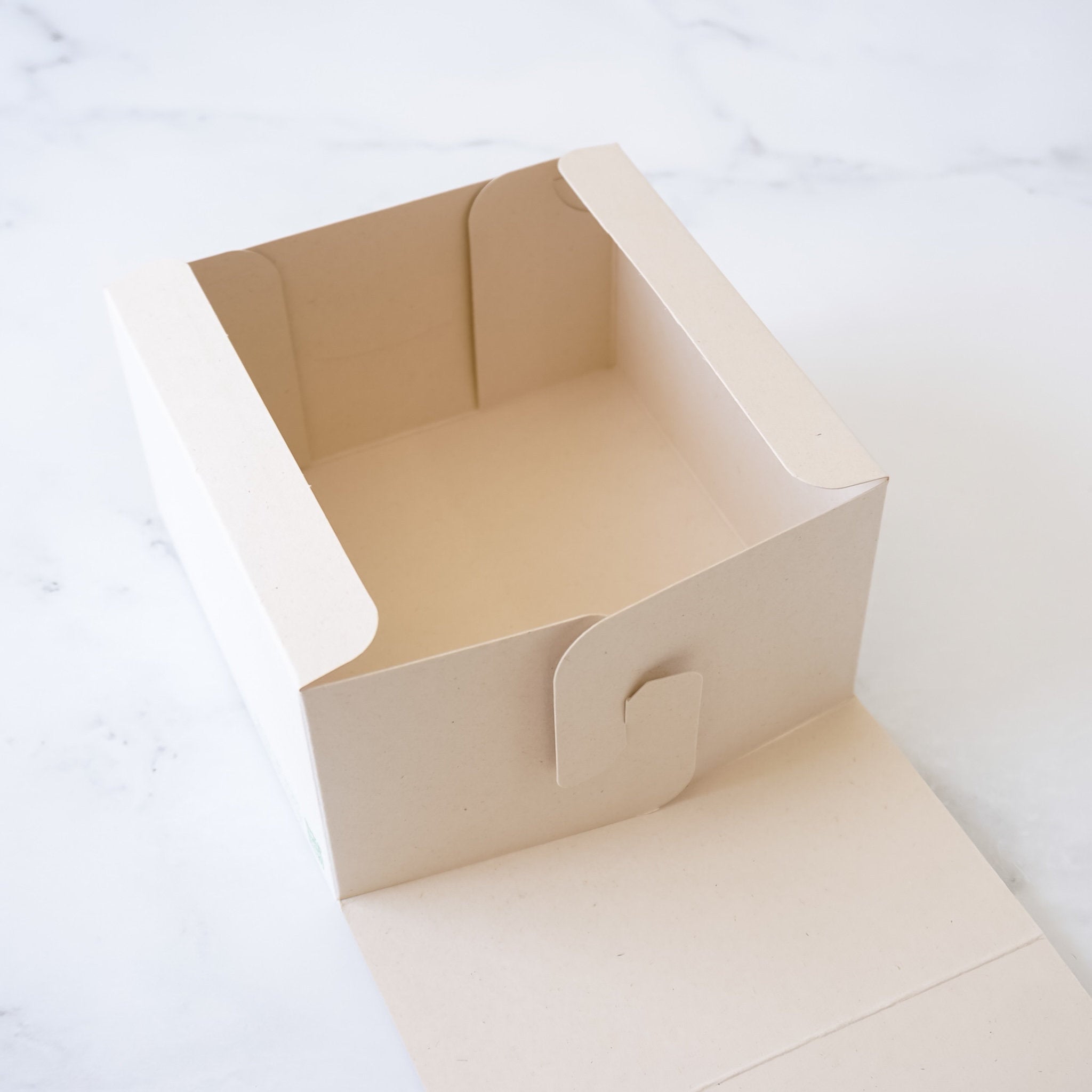 Beige paper bakery box on a white background