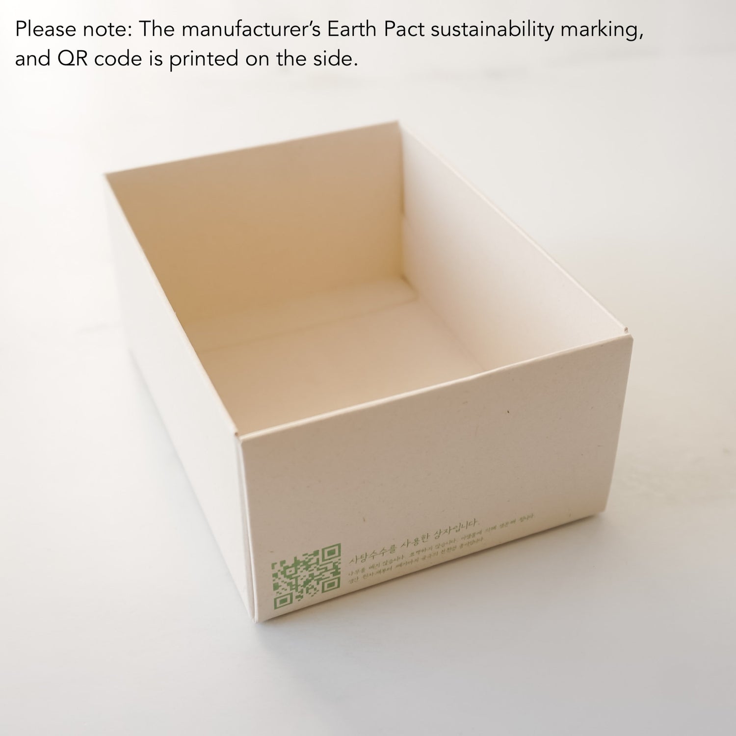Beige box with sustainability marking and QR code on a white background