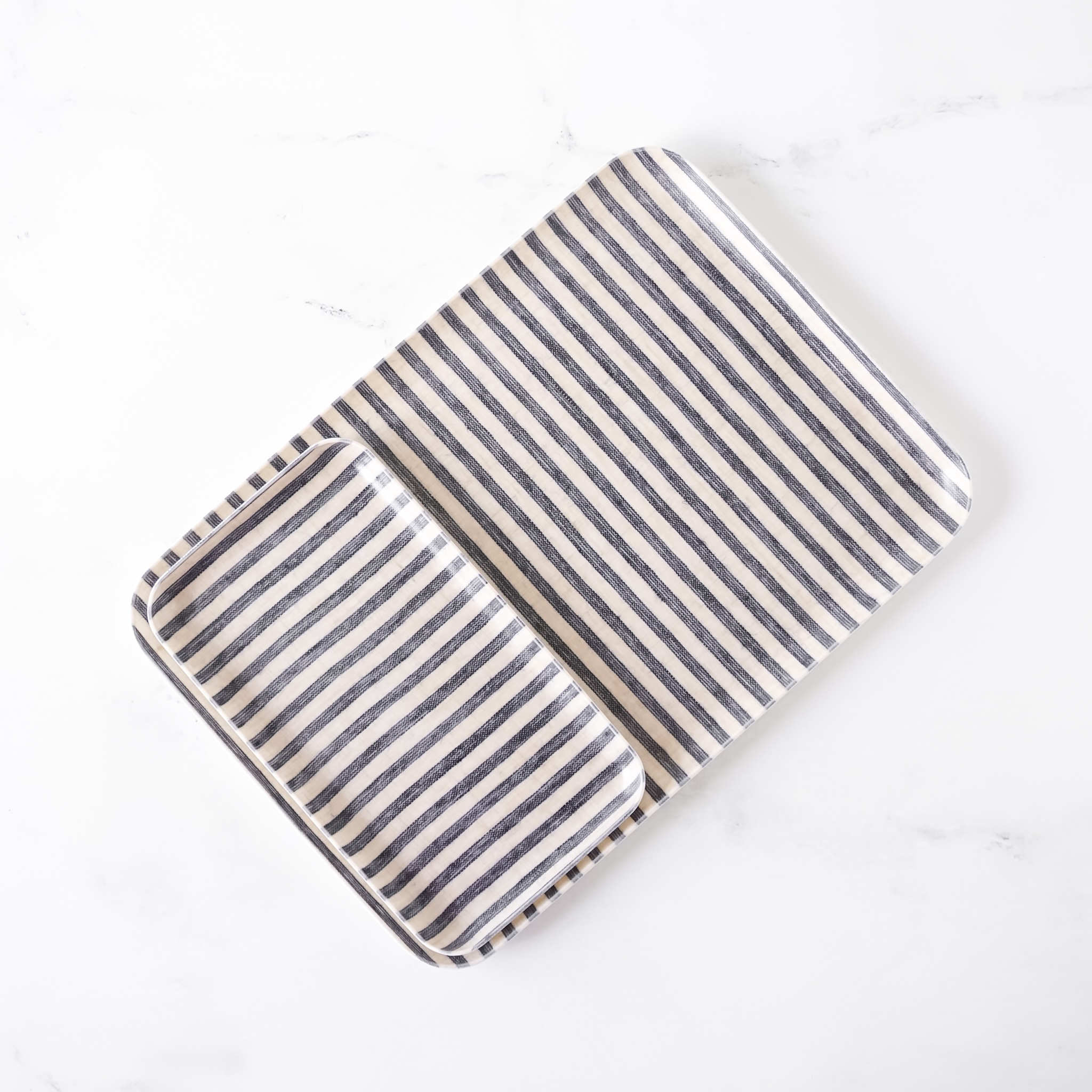 Striped linen coated serving tray with dark navy blue and beige stripes on a white background