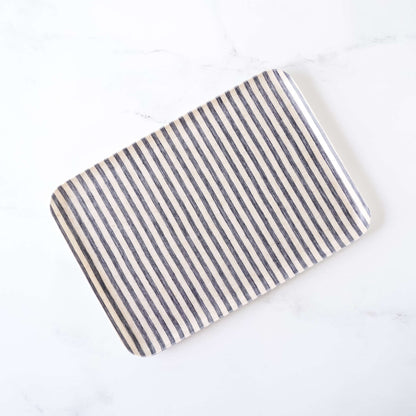 Rectangular linen coated tray with dark navy and natural striped pattern on a white background