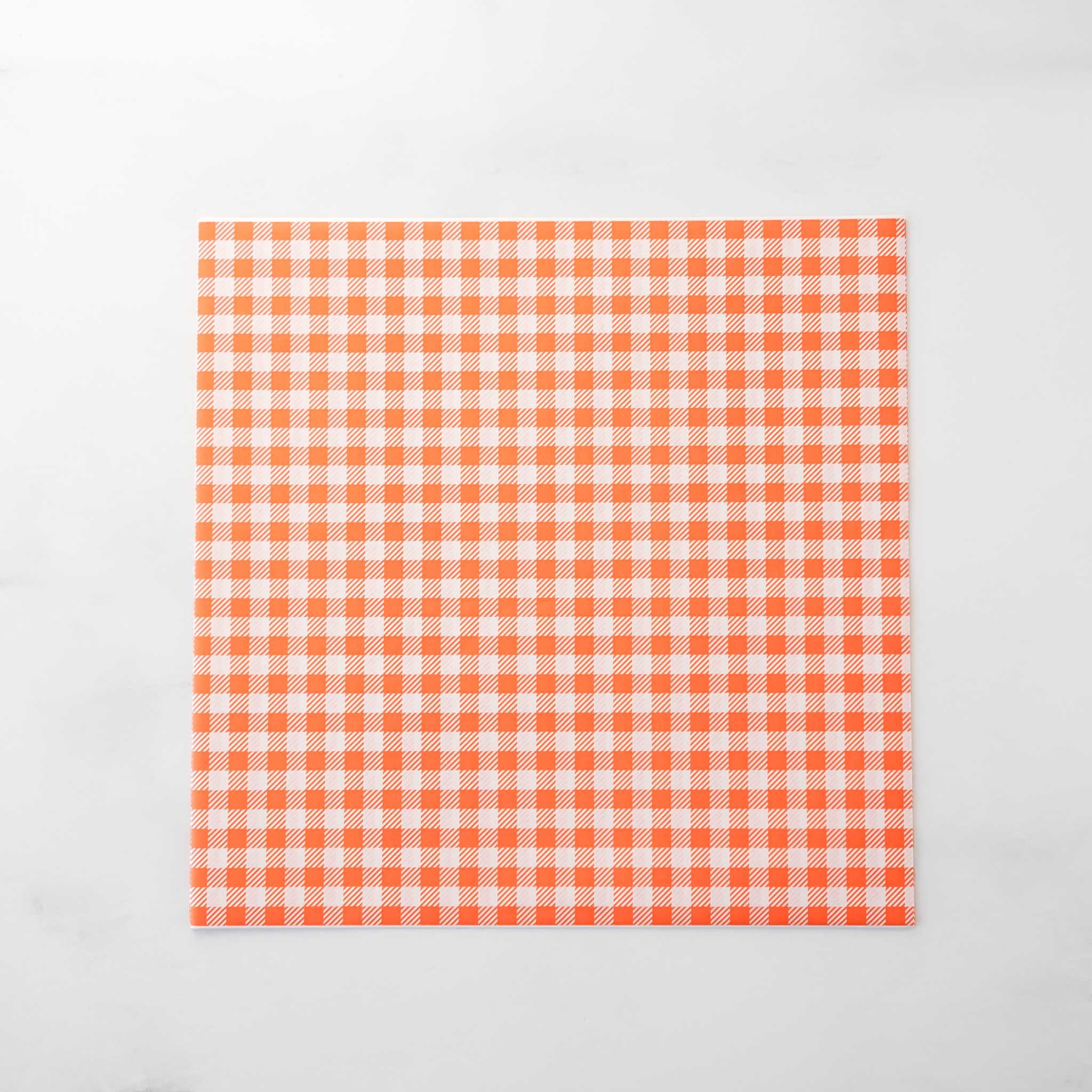 Orange and white checkered deli paper on a light gray background