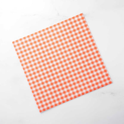 Orange and white checkered deli paper on a white background