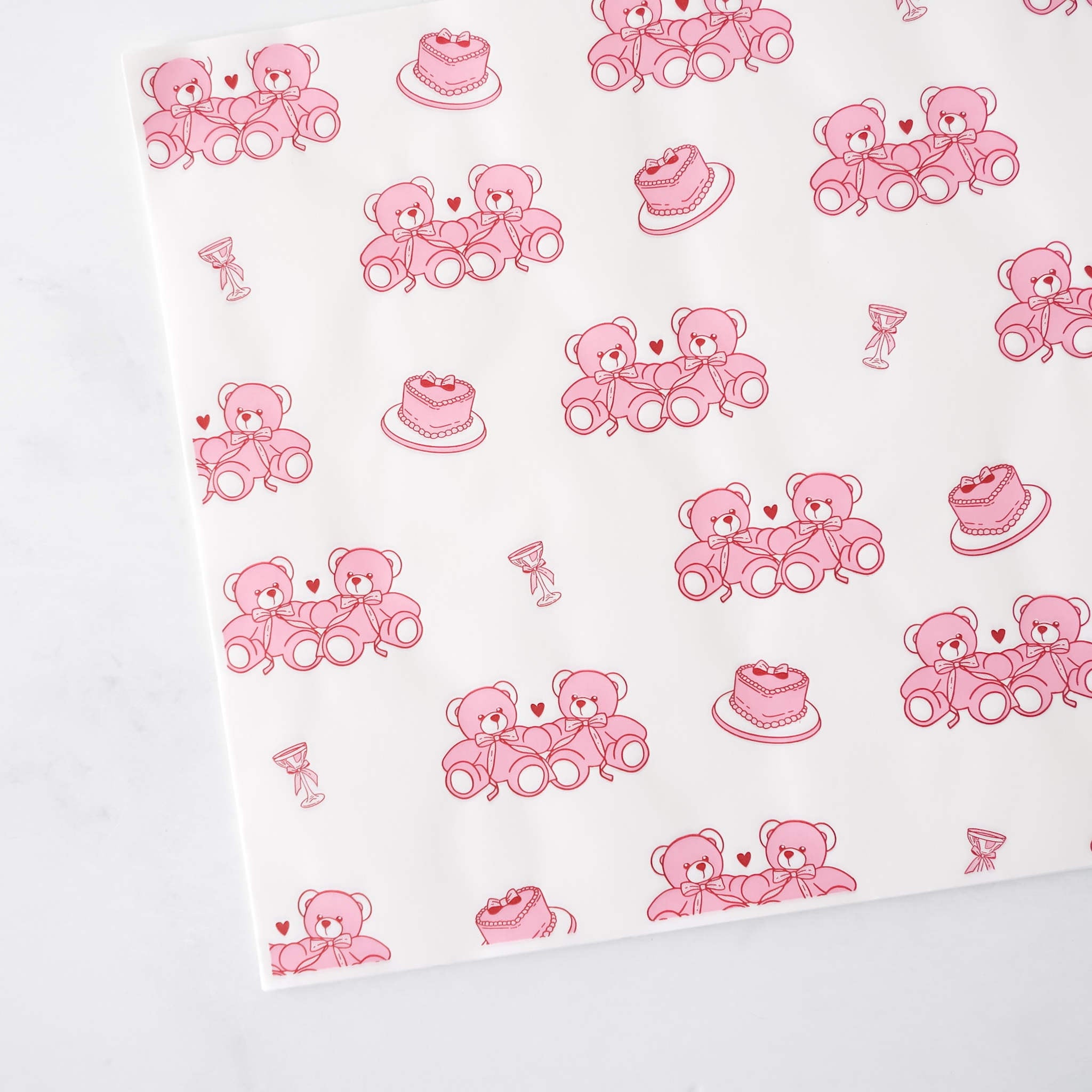 White paper with pink teddy bear and cake pattern