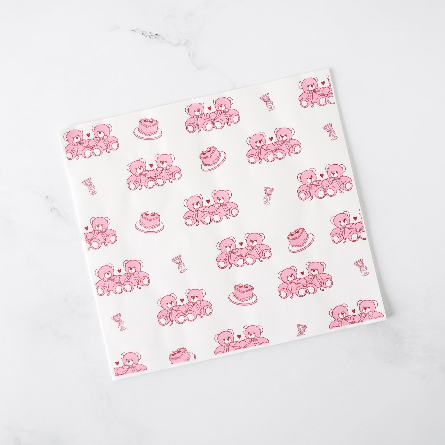 White paper with pink teddy bear and cake pattern on a white background
