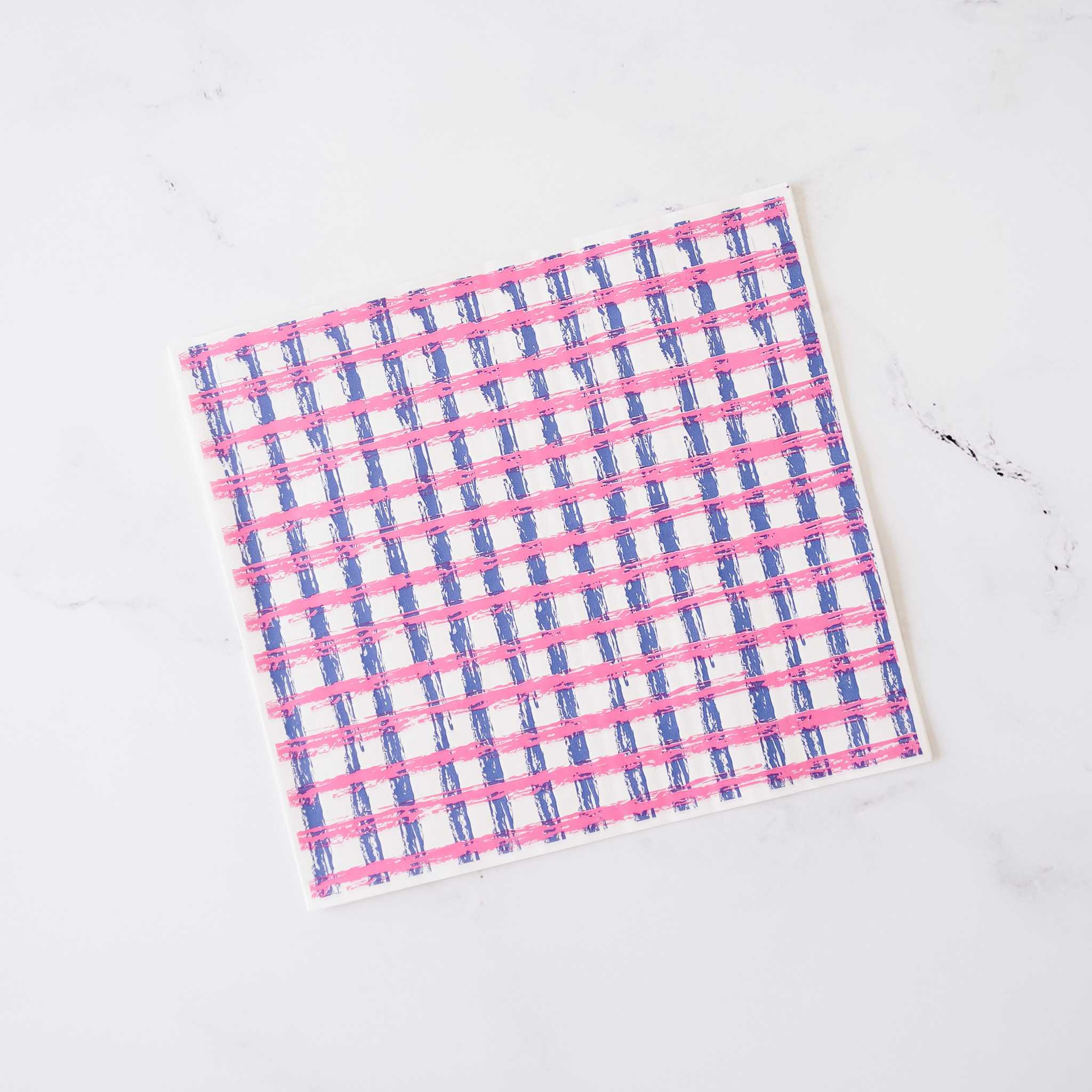 A white square with a pink and blue gingham pattern. The pattern is made of thin lines that are slightly faded and have a brushstroke effect.